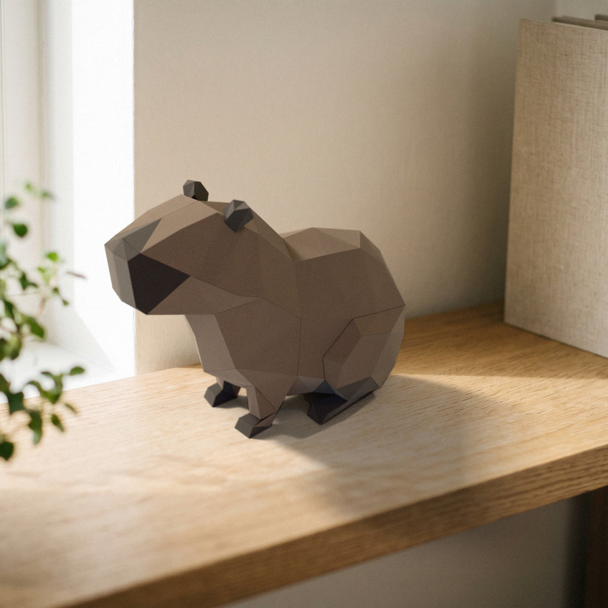 Paper Capybara model on a bookshelf
