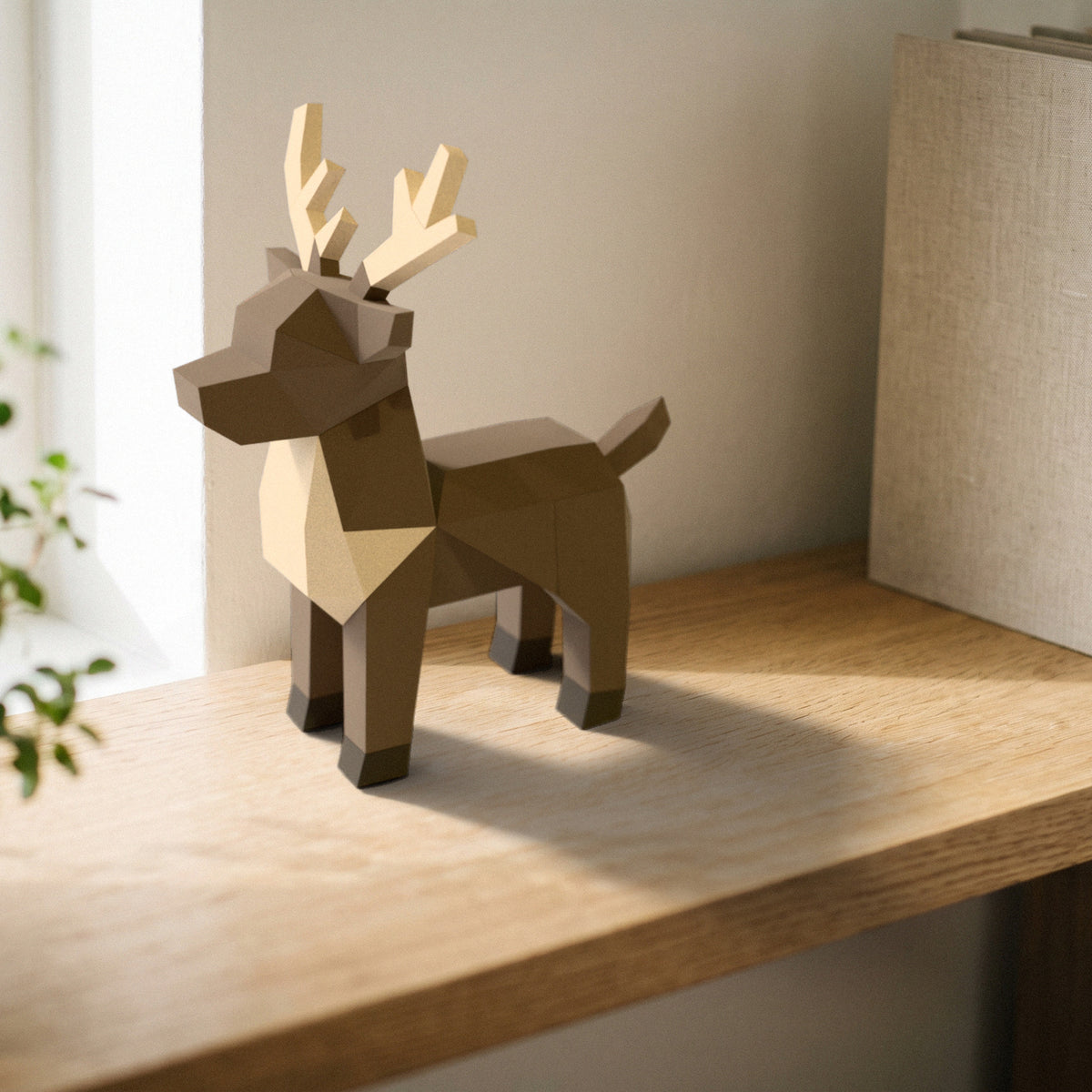 Paper Reindeer model on a bookshelf