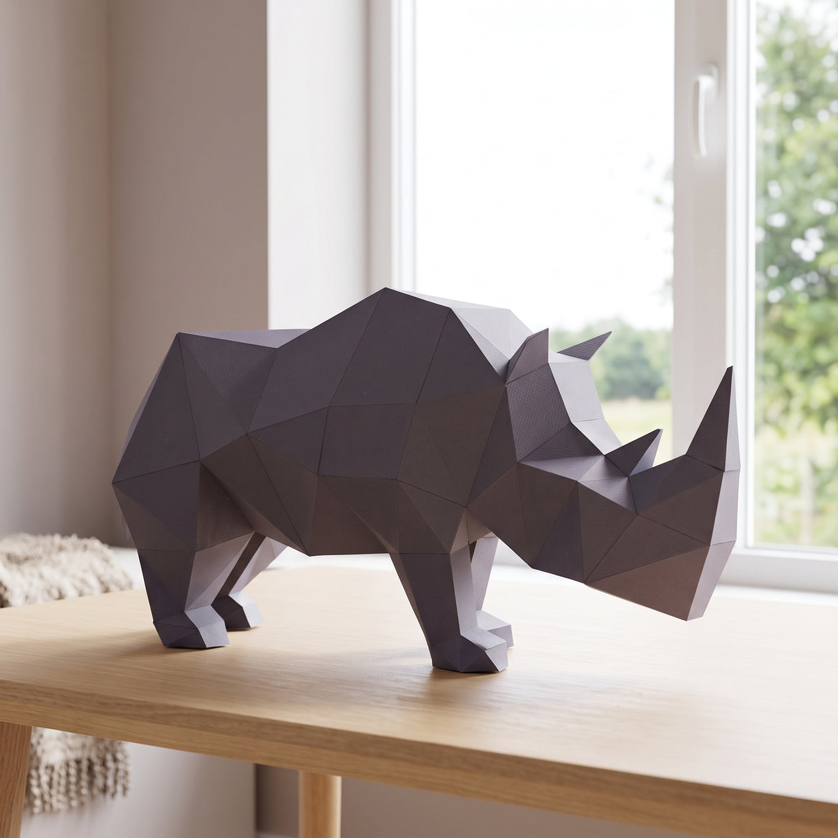 Paper Rhino model on a table by the window