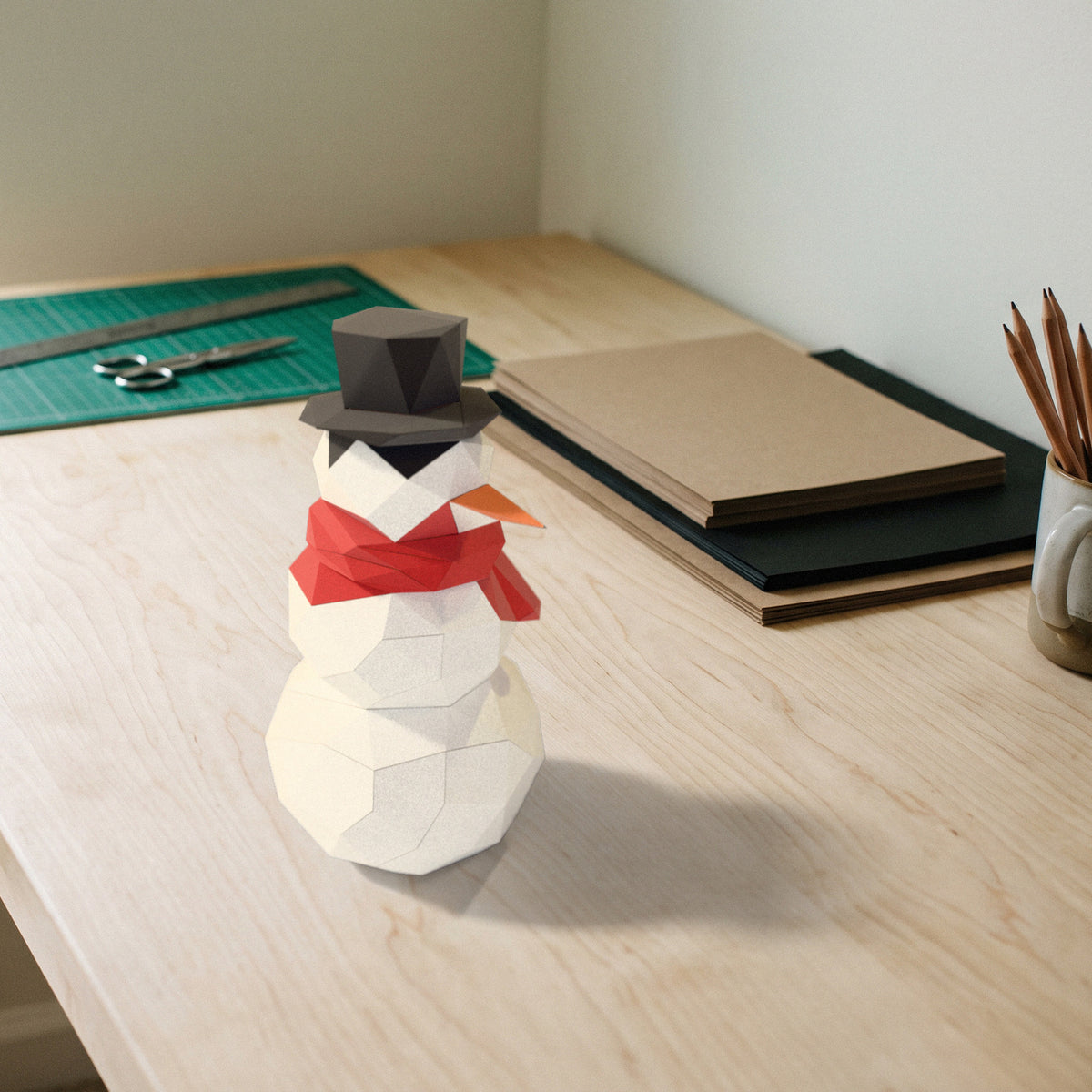 Paper Snowman model on a craft desk